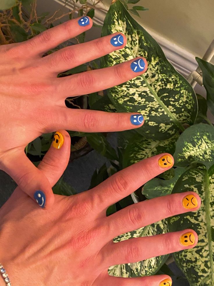 Whimsical Emoticon Nail Designs: Cheerful Blue and Yellow Expressions for Playful Personal Style.