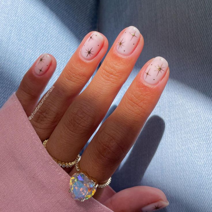 Whimsical Nail Art: Soft Pink Base with Golden Stars for Elegant Occasions