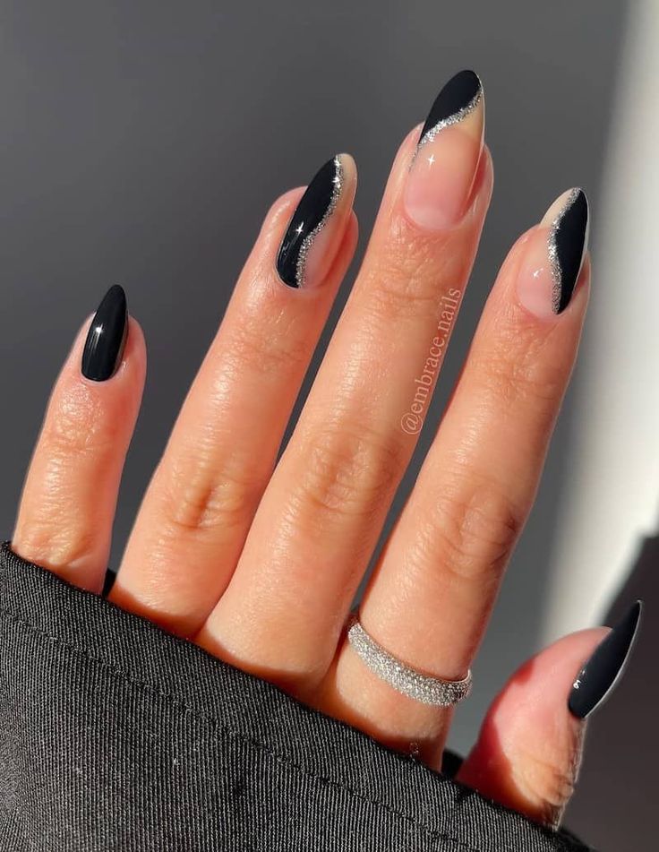 Elegant Almond-Shaped Nails with Striking Black Polish and Delicate Silver Accents.