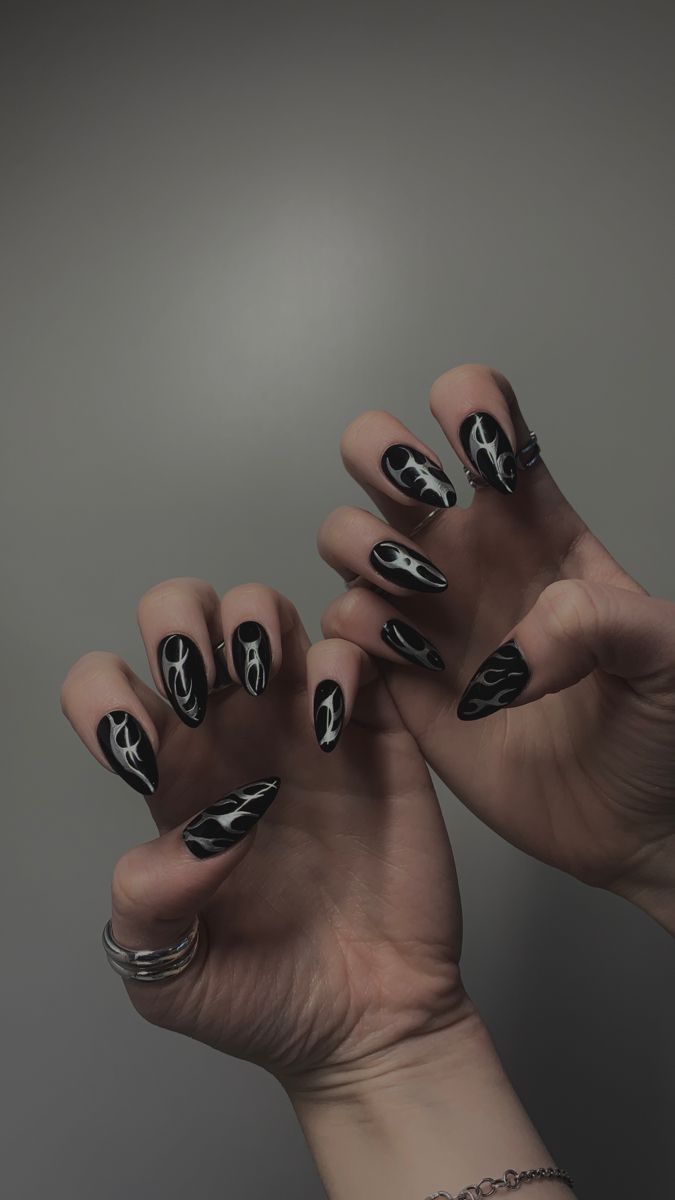 Bold Black Nails with Intricate White Flame Designs for an Edgy Artistic Statement.