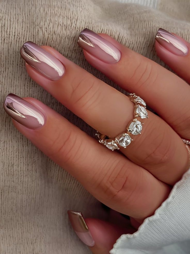 Chic French Tip Nail Design with Glossy Nude and Metallic Finish Complemented by Sparkling Rings.