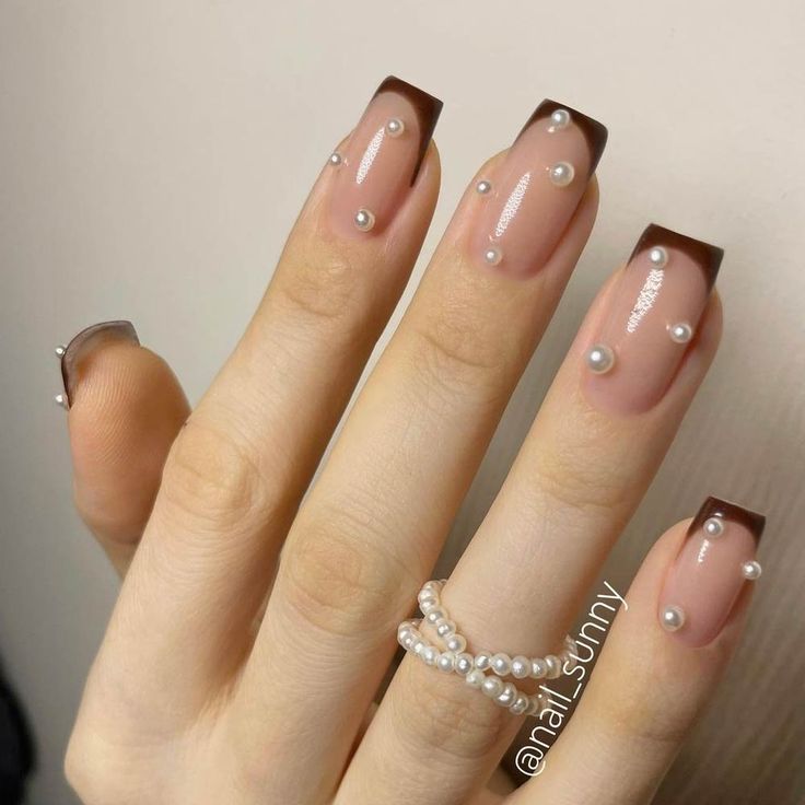 Sophisticated French Tip Nail Design with Deep Brown Edge and Pearl Accents.