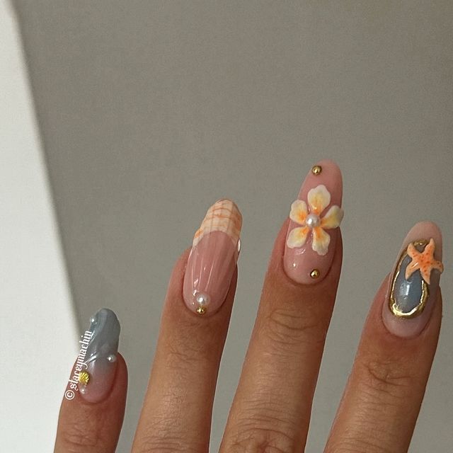 Chic Pastel Nail Design with Floral Accents and Elegant Gold Embellishments.