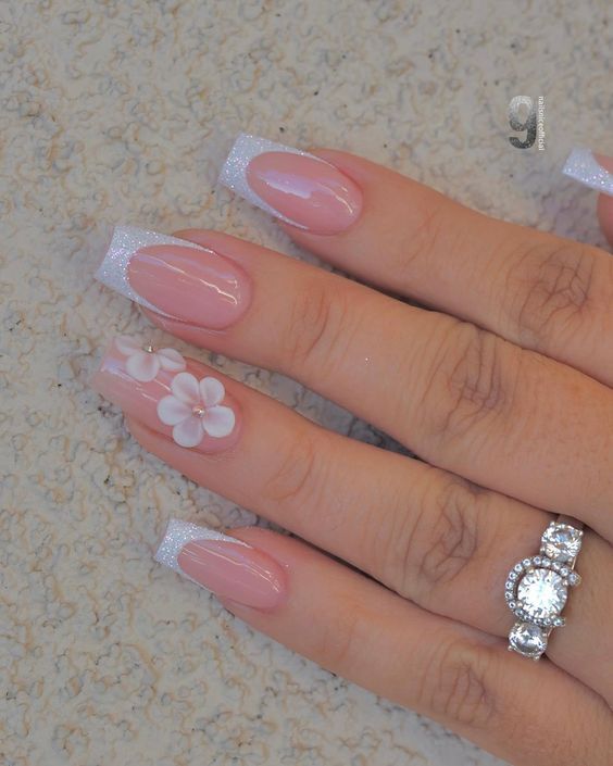 Elegant Pink and Glittery White Nail Design with Floral Accents for Special Occasions.