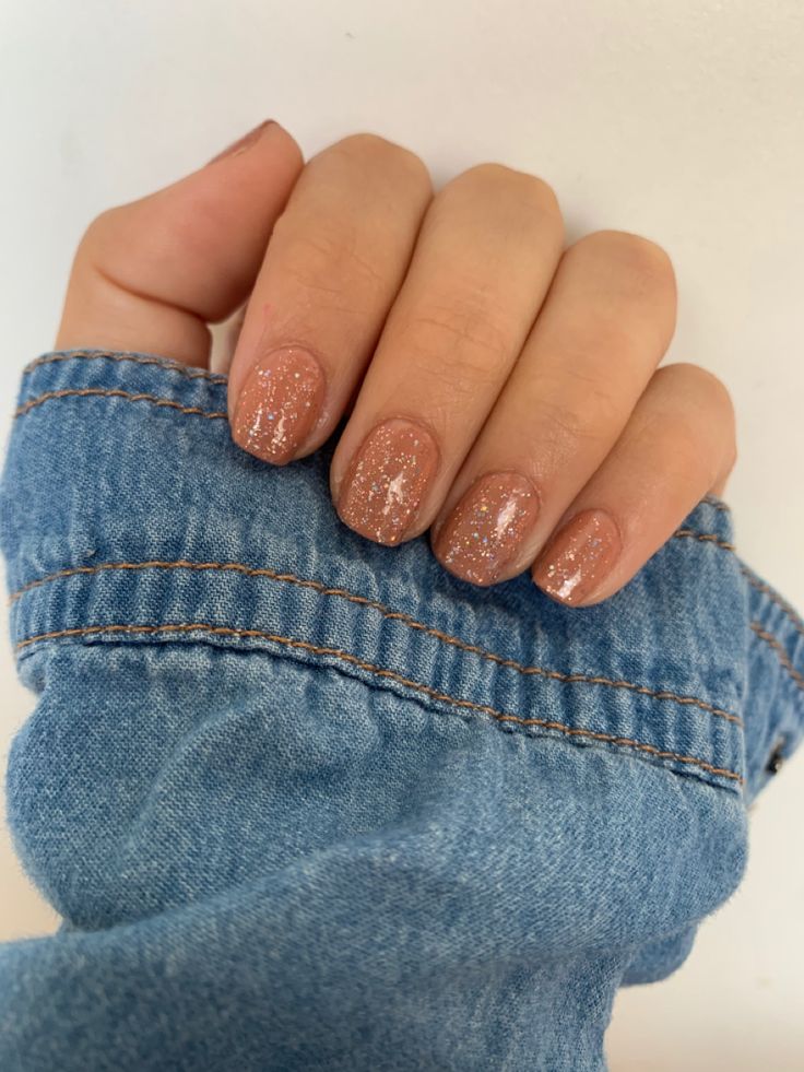 Elegant Glittery Nude Nail Design: Soft Pink Base with Chic Denim Jacket Style.