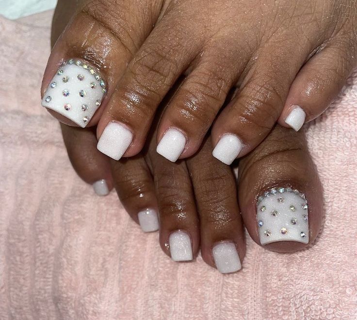 Sophisticated Glossy White Nail Design with Sparkling Rhinestone Accents.