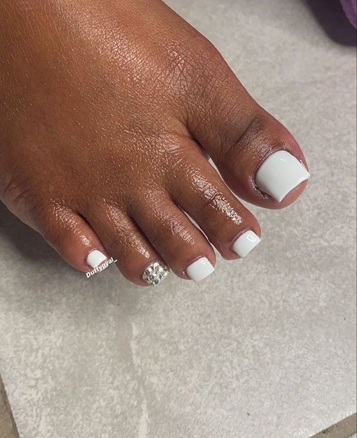 Sophisticated Elegant White Pedicure with Glossy Finish and Rhinestone Accent.