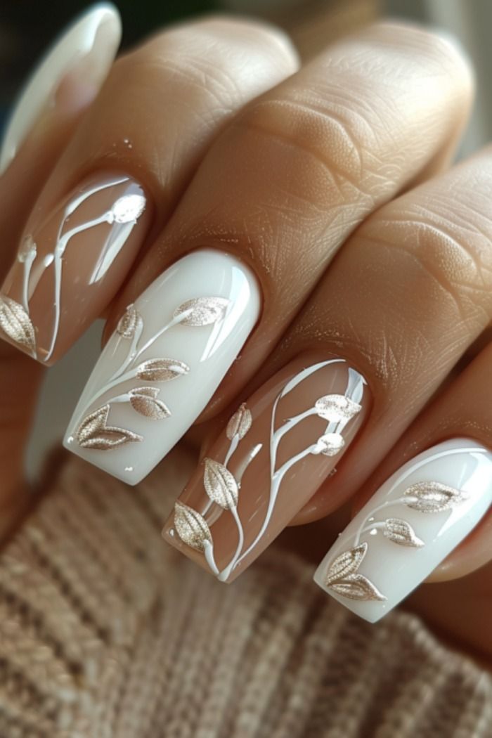 Elegant Floral Nail Design with White and Nude Shades, Intricate Vine Patterns, and Glossy-Matte Finish.