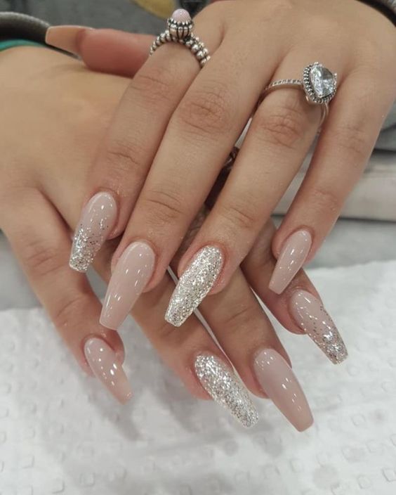 Chic Almond-Shaped Nail Design: Soft Nude with Shimmering Silver and Glitter Accents