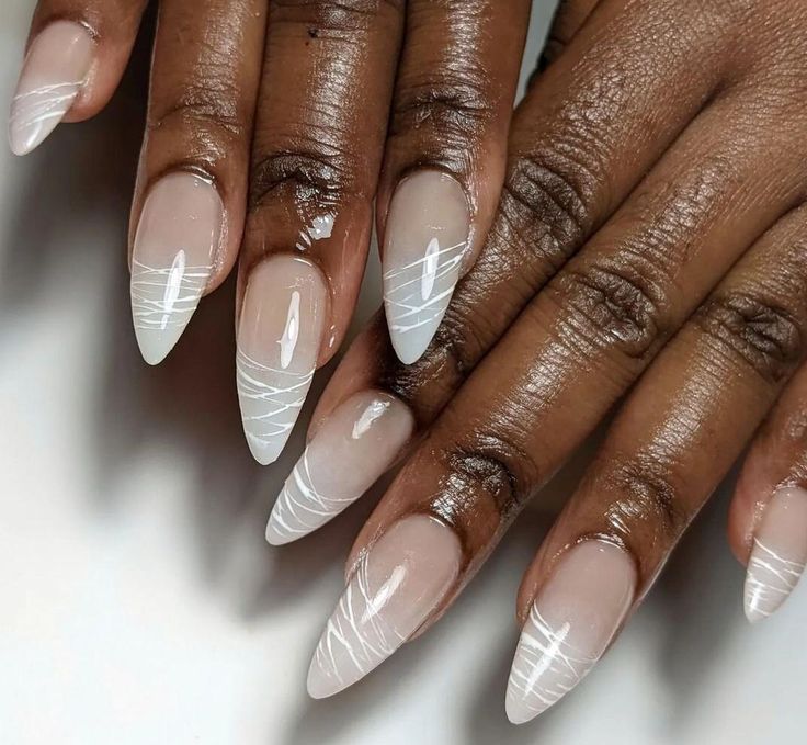 Chic Almond-Shaped Nails with Subtle Ombre and Delicate White Accents.