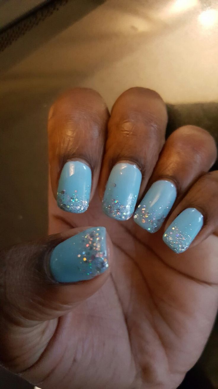 Elegant Light Blue Ombre Nail Design with Glitter Tips for a Playful Aesthetic.