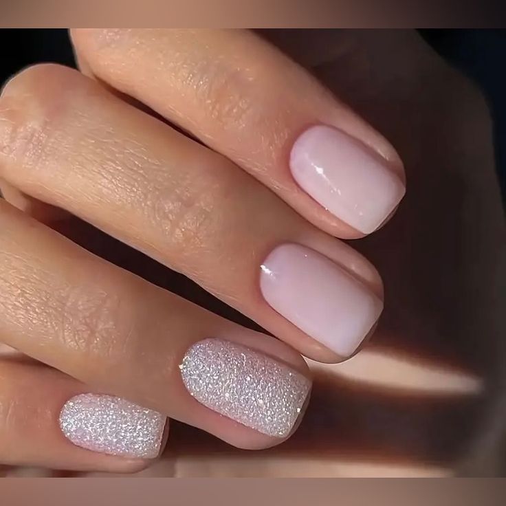 Sophisticated Nail Design: Soft Pink Gradient with Glamorous White Glitter Accent.