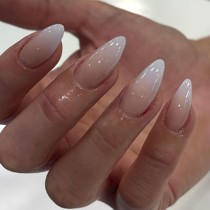 Sophisticated Almond-Shaped Ombre Nails: Translucent White to Sheer Nude.