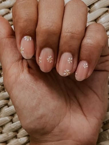 Charming Floral Nail Design: Soft Nude Base with Delicate White Flowers for a Fresh, Feminine Look.