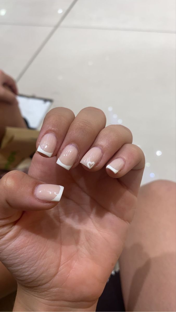 Charming Elegant French Manicure with Heart Accent for a Refined Look.