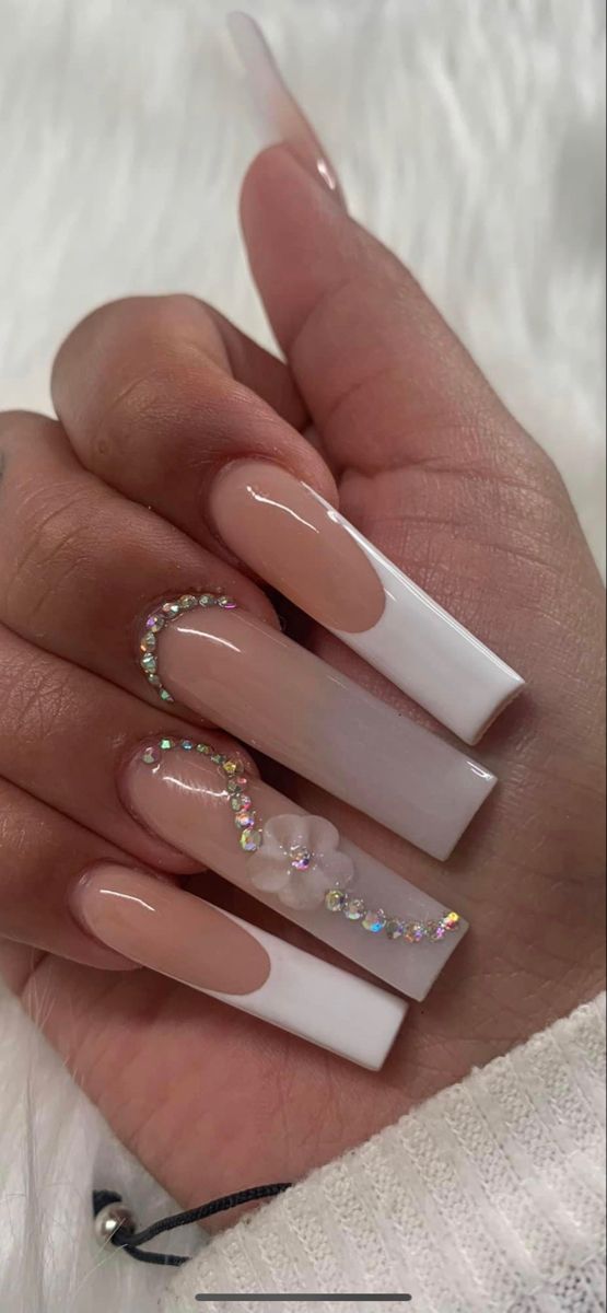 Sophisticated Long Glossy Nude and White Acrylic Nail Design with Rhinestones and Floral Accent.