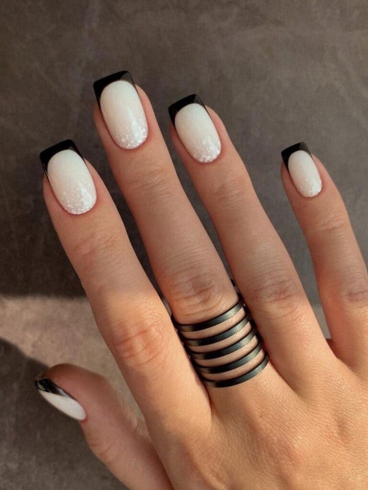 Elegant Black and White French Tip Nail Design with Sparkle and Chic Ring Accent