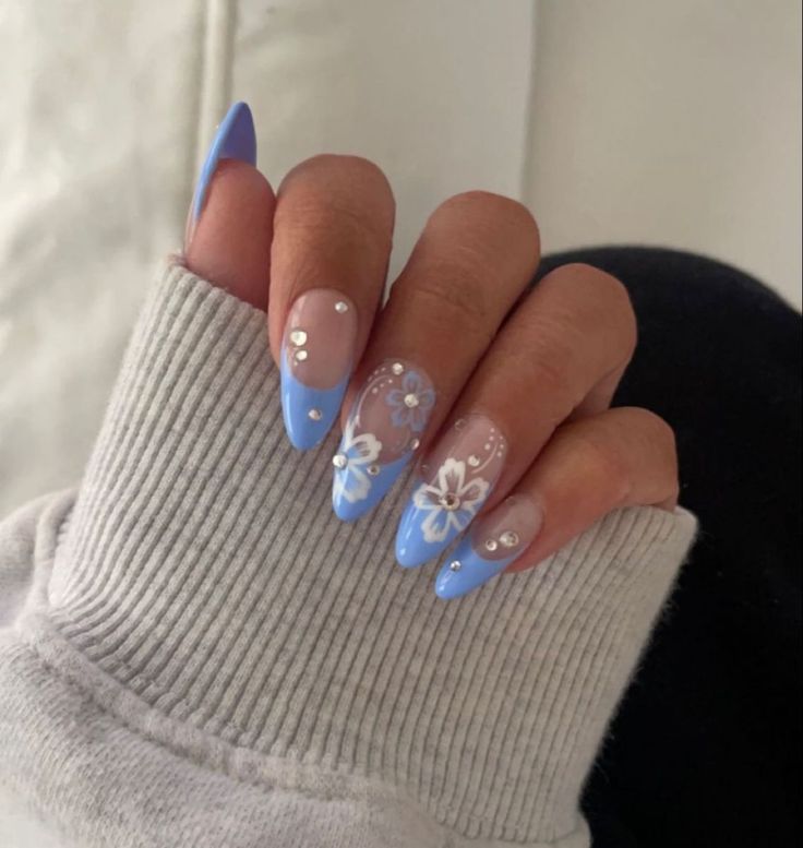 Elegant Soft Blue and Nude Nail Design with Floral Patterns and Rhinestone Accents