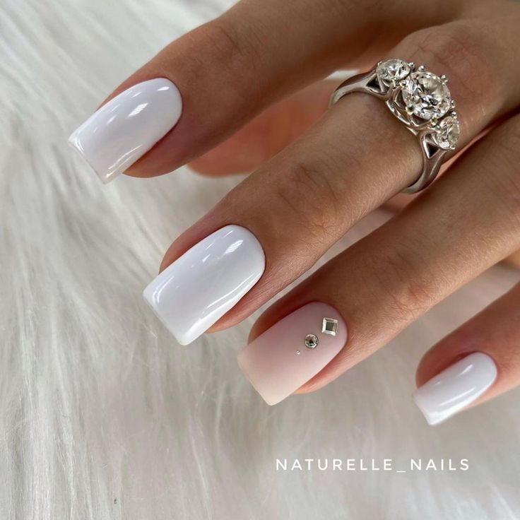 Sophisticated Glossy White Nail Design with Soft Pink Gradient and Sparkling Rhinestones.