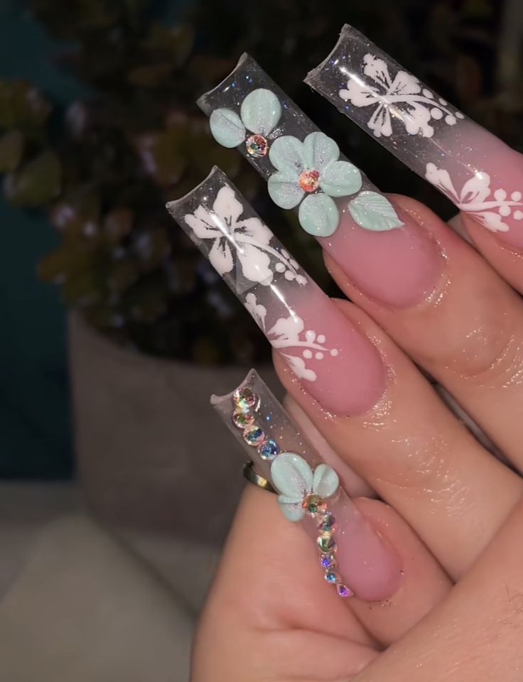 Elegant Floral Acrylic Nail Design with Gems and Soft Blue Accents for Spring Occasions.