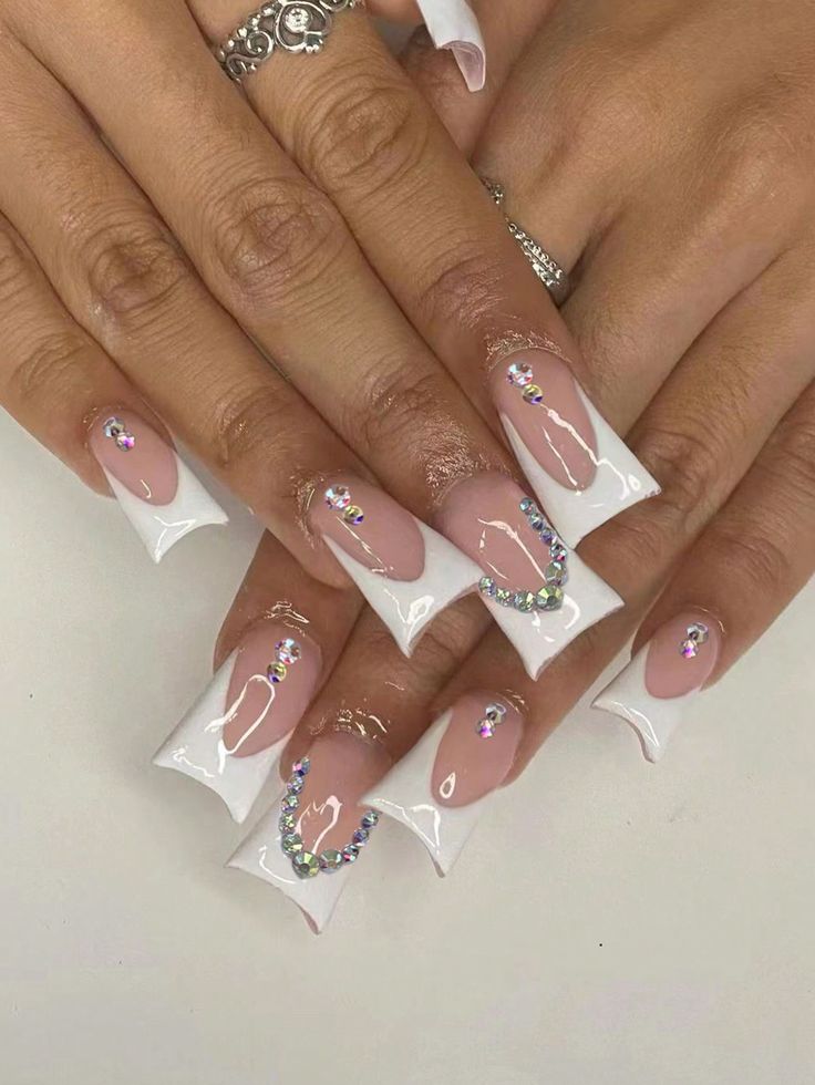 Chic Nail Design: Modern French Manicure with Glossy Nude, White Tips, and Elegant Rhinestone Accents.