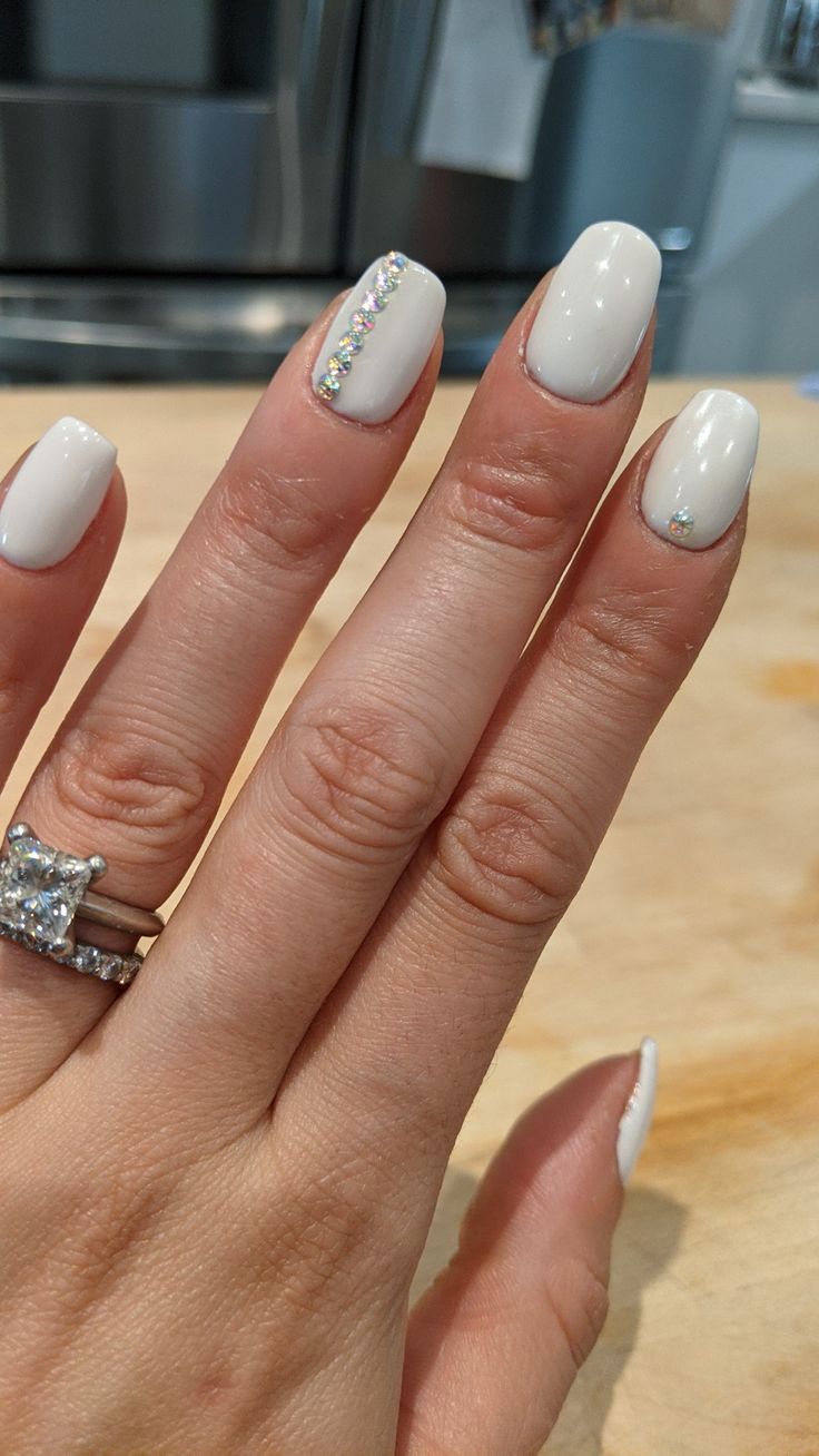 Sleek Elegance: Sparkling White Nails with Chic Accent Design.