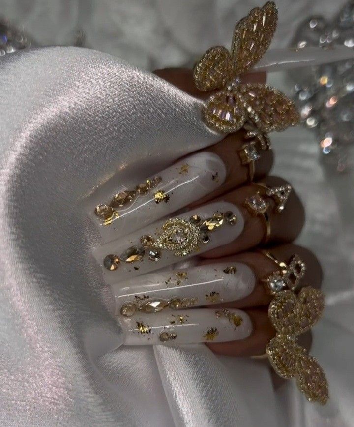 Elegant White Nail Design with Gold and Rhinestone Embellishments