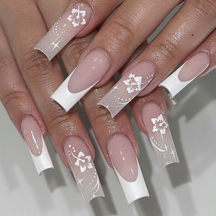 Sophisticated Nude and White Nail Design with Floral Patterns and Glossy Finish.