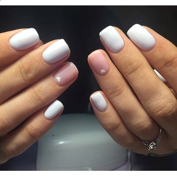 Chic Minimalist Nail Design with Glossy White Finish and Subtle Heart Accents.