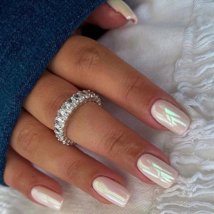 Sophisticated Iridescent White Nail Design Enhanced by a Delicate Silver Ring