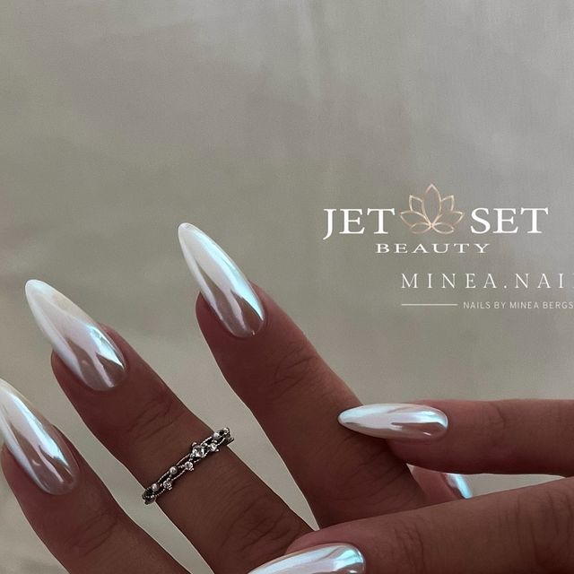 Stunning Elegant Stiletto Nails with White and Iridescent Finishes Accented by a Silver Ring for a Chic Aesthetic.