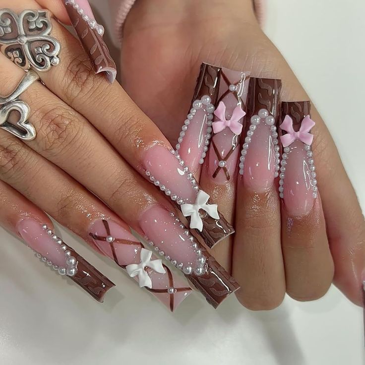 Whimsical Chocolate-Inspired Nail Art with Soft Pink Hues, Pearls, and Bows.