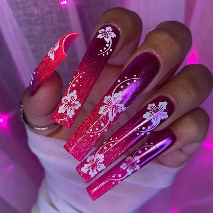 Bold Ombre Nails with Floral Patterns in Pink and Purple.