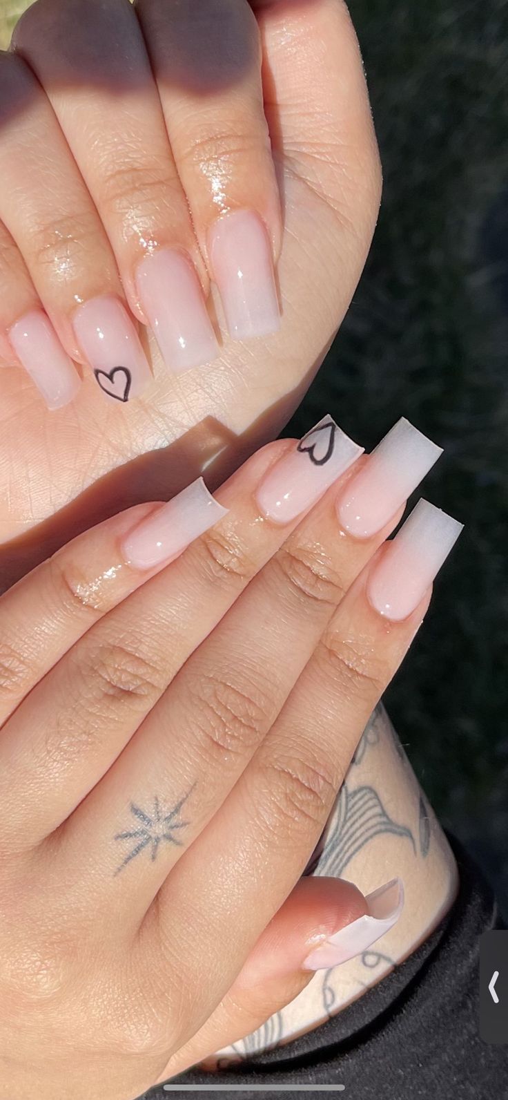 Chic Soft Pink Ombre Nails with Minimalist Black Heart Accents.