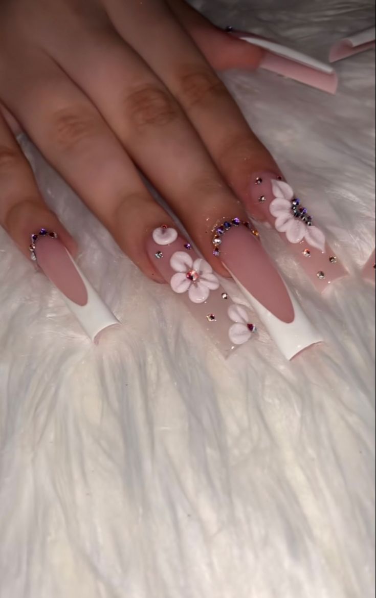 Chic Floral Nail Design with Elongated Tips and Elegant Nude Base.