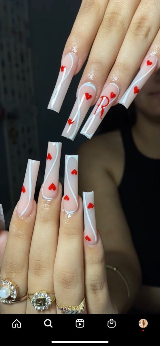 Charming Romantic Nail Design with Clear Base, White Swirls, and Vibrant Red Hearts