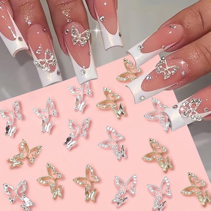 Chic Glossy Nude and White Tip Nail Design with Rhinestones and Butterfly Charms for Glamorous Occasions.