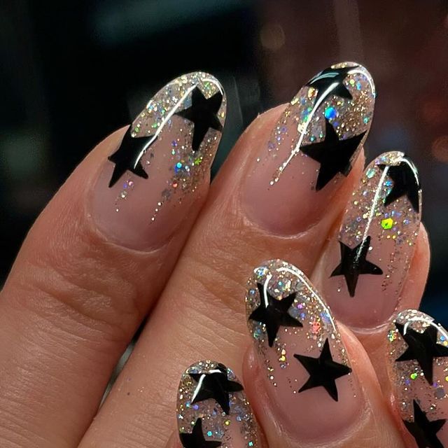 Sparkling Star-Themed Nail Design with Bold Black Shapes and Holographic Glitter.