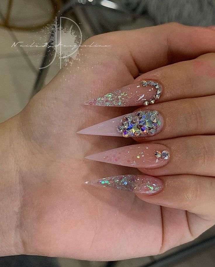 Elegant Stiletto Nails: Soft Pink Base with Iridescent Glitter and Sparkling Rhinestones.