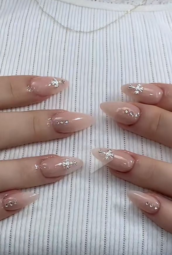 Sophisticated Soft Nude to Pink Gradient Nail Design with Silver Embellishments and Floral Accents.