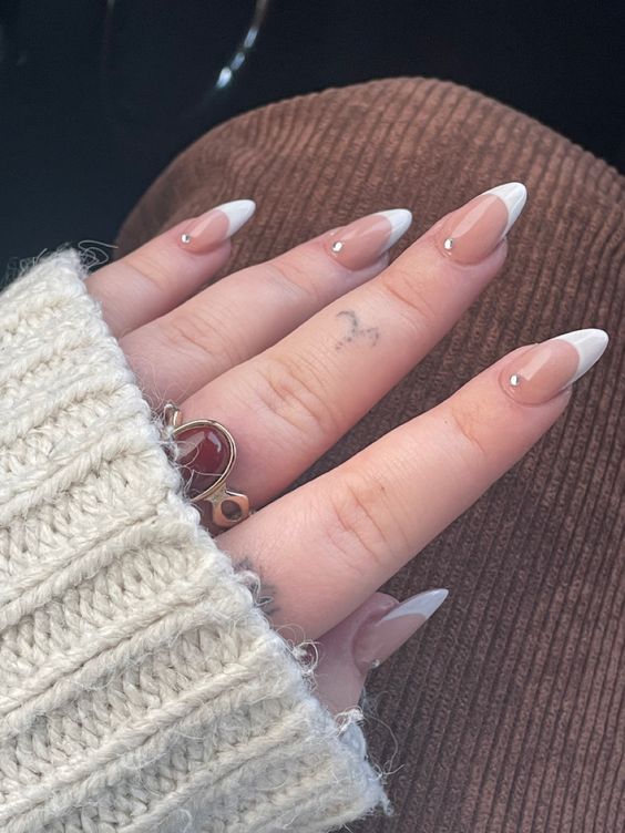 Chic and Sophisticated: Elegant Nude Nails with Classic French Tips and Rhinestone Accents.