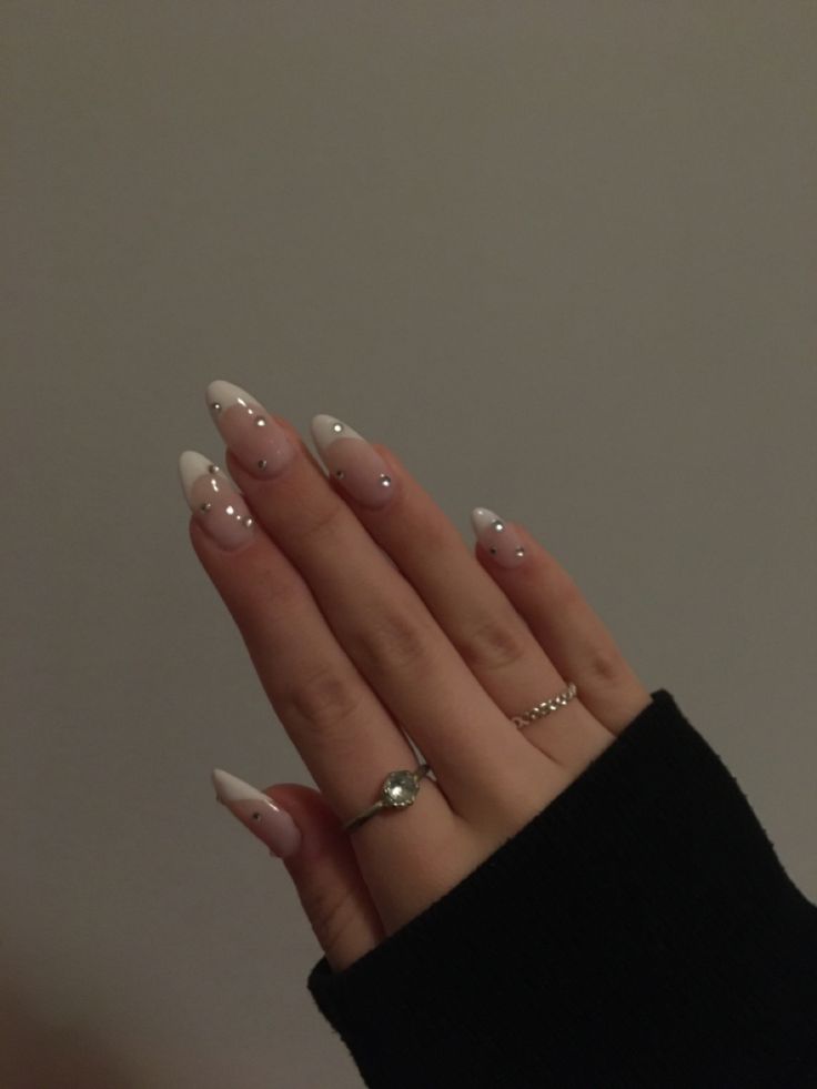 Chic White Base Nail Design with Delicate French Tips and Sparkling Rhinestones.