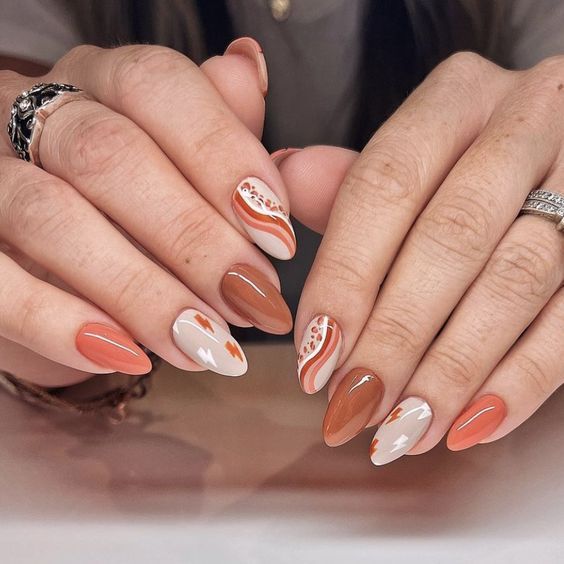 Stylish Nail Design with Warm Terracotta and Peach Tones Featuring Creative Patterns.