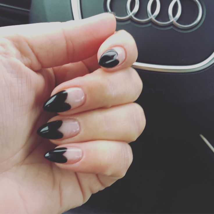 Chic Almond-Shaped Nail Design: Glossy Black and Nude Half-Moon Contrast.