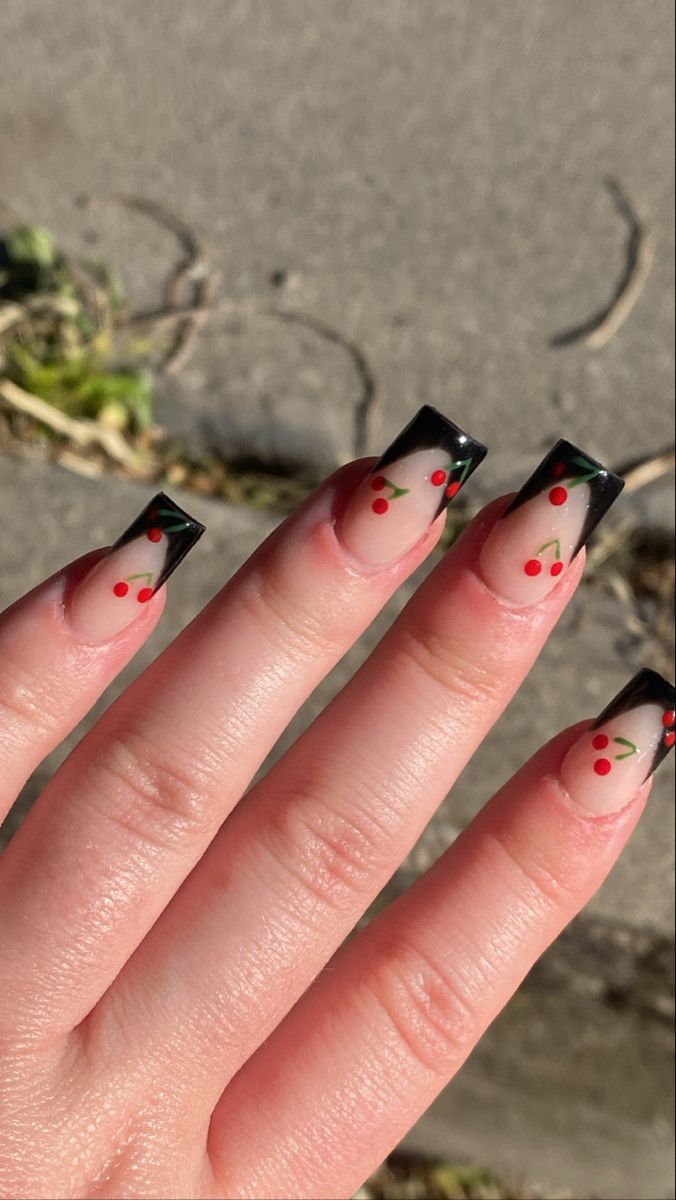 Sophisticated Black-Tipped Nude Nails with Playful Cherry Motifs.