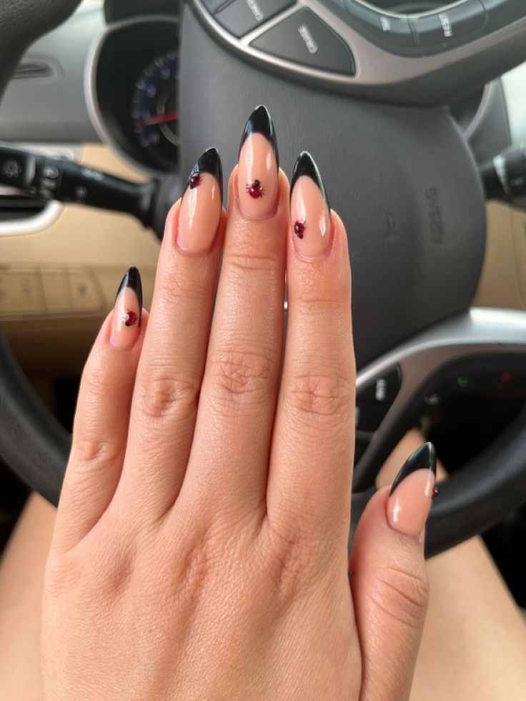 Elegant French Tip Nails with Glossy Black Outline and Red Gem Accents.