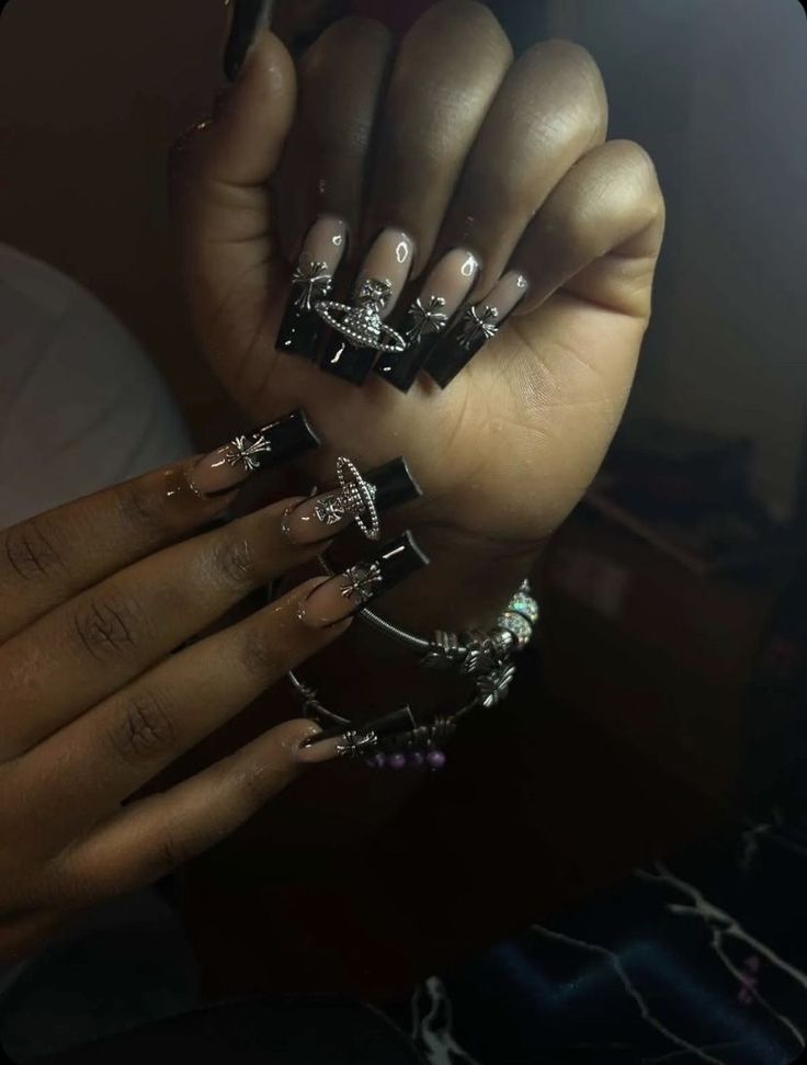 Elegant Nude and Black Nail Design with Rhinestones and Chic Accessories.