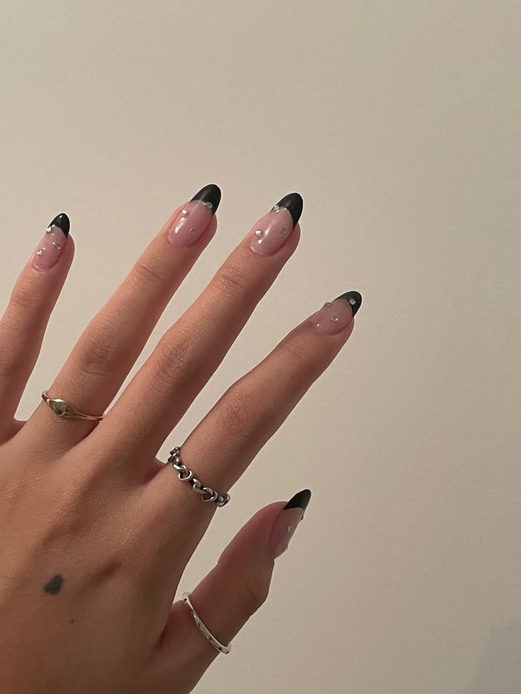 Sophisticated Nude and Black Tip Nail Design with Rhinestone Accents