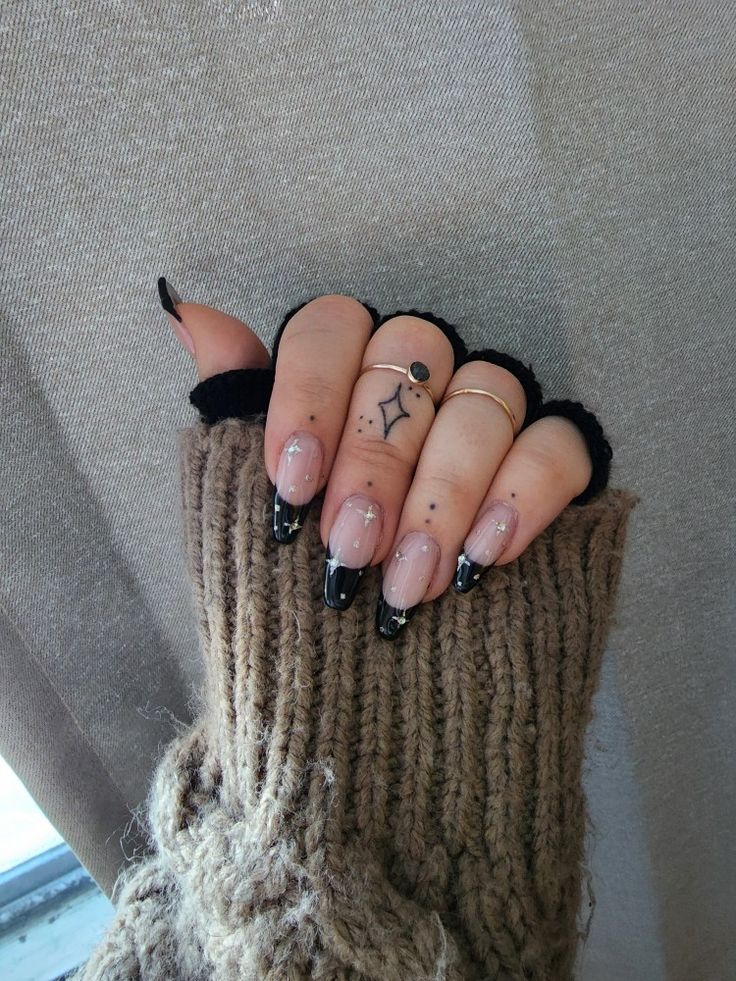 Chic Contrast: Stylish Acrylic Nails with Nude and Black Tips Complementing Cozy Fingerless Gloves.