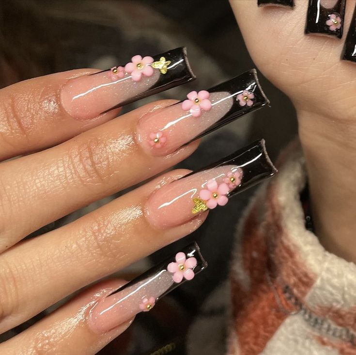 Sophisticated Nail Design with Long Square Tips, Glossy Black and Soft Pink Accents, and Floral Glamour.